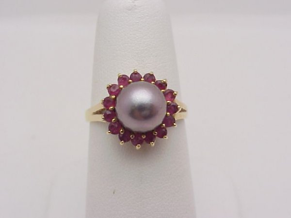 14kyg black pearl and ruby ring: Lady's 14kyg black pearl ring weighing3.2 grams. This piece consists of one black tahitian pearl measuring 8mm with a circle of rubies around it. Finger size is 63/4.