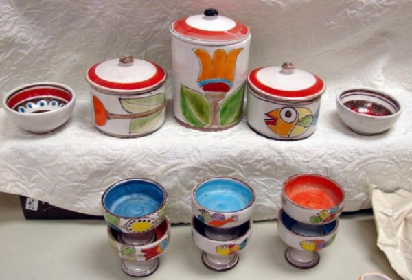 14 pcs. DeSimone Pottery - 3 canisters & dishes: 14 pieces of DeSimone Pottery consisting of 3 covered canisters, 2 small bowls and 6 footed desert dishes. Individually hand crafted and hand painted with unleaded colors, De Simone pottery adds cheer