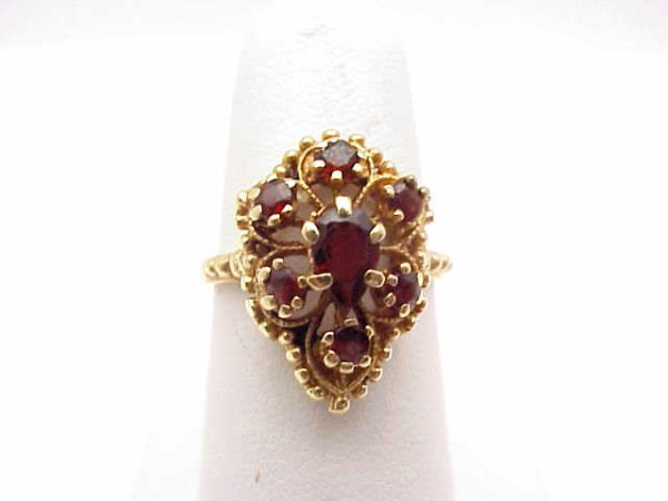 Lady's 14kyg garnet ring: Lady's 14kyg ring weighing 4.6 grams. This ring contains six round garnets surrounding one pear shaped garnet. Has filigree pear shape design. Finger size 61/2.