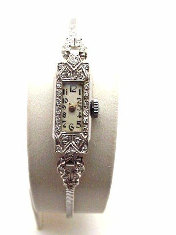 Lady's Berlis platinum/14k diamond watch: Lady's Berlis platinum/14kwg watch weighing 15 grams. This piece has white rectangular dial with gold hands, mechanical movement and diamonds around the case. Band matches case with diamonds in 14k wh