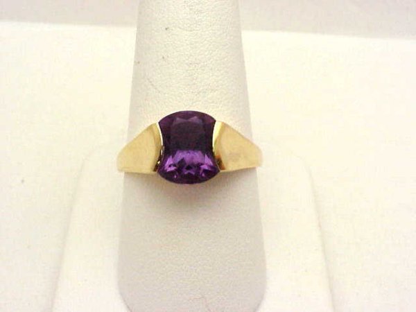 Lady's 14kyg amethyst ring: Lady's 14kyg fancy amethyst ring weighing 3.9 grams. This ring contains one fancy cut amethyst weighing 2.52ct in the shape of an hour glass, channel set with tapered shank. Finger size 10.