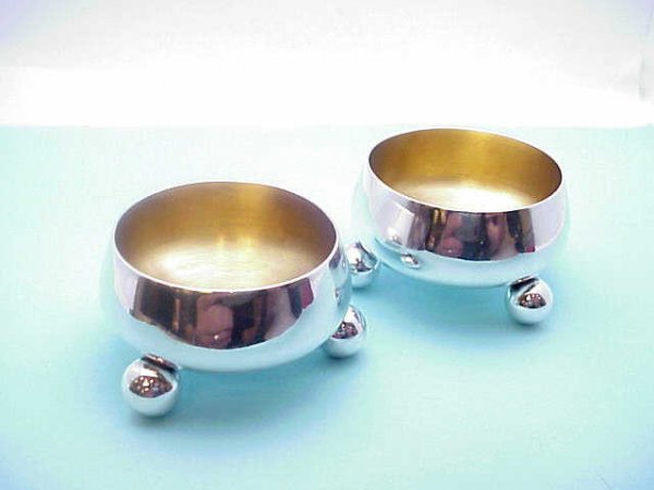 Pair of Tiffany sterling salt cellars: Pair of Tiffany sterling salt cellars from the late 1800s, 2" in diameter, 1 1/4" high, with round feet and gold lining, 77 gr. in weight.