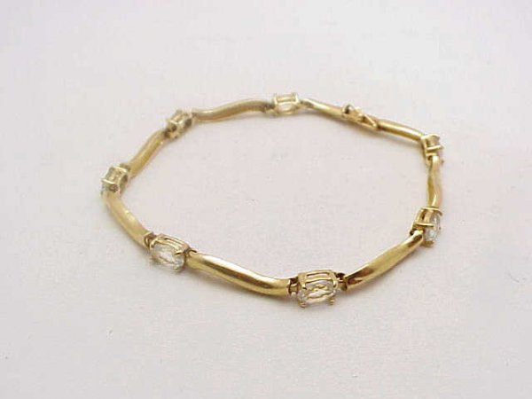Lady's 14kyg aquamarine bracelet: Lady's 14kyg aquamarine bracelet weighing 7.3 grams. This bracelet has 7 oval shaped aquamarine measuring 6X4mm prong set each separated by 1/2" bar. 7 inches in length.