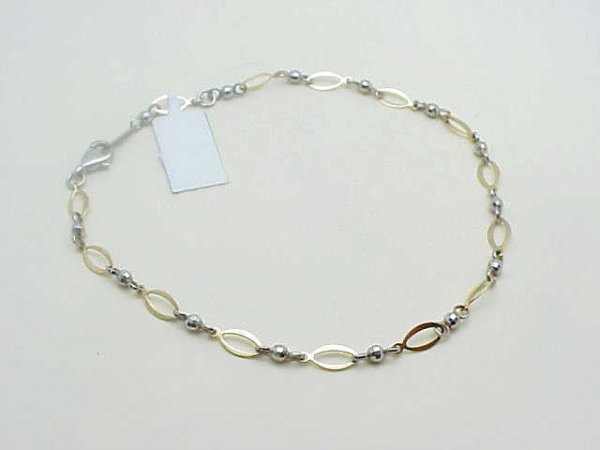 Lady's 14k 2tone ankle bracelet: Lady's 14k 2tone ankle bracelet with white diamond cut balls and yellow oval shaped links. 10" in length.