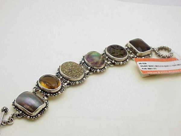 Stephen Dweck sterling bracelet: Sterling bracelet by designer Stephen Dweck containing whiskey quartz, rutilated quartz, golden shell mabe pearl and druzy all bezel set with toggle clasp and sells at Saks Fifth Avenue.