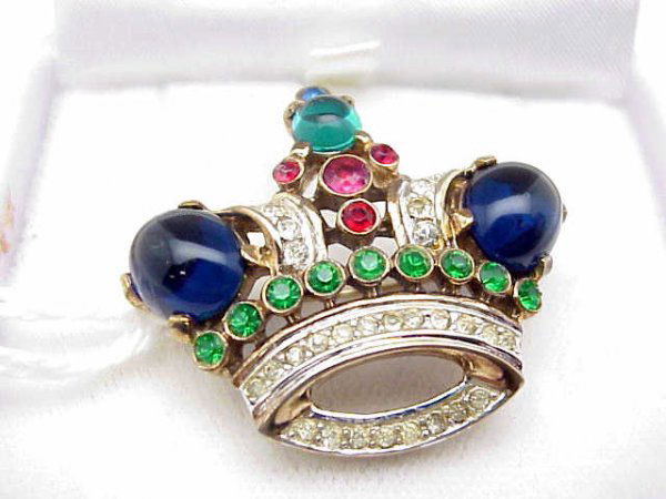 Costume crown pin by Trifari: Lady's pin in the shape of a jeweled crown by Trifari has synthetic cabochon sapphire, emerald, prong set emeralds and diamonds.