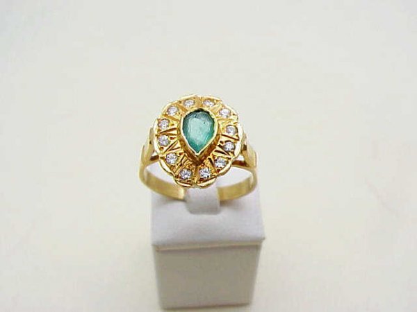 Lady's 18kyg emerald/diamond ring: Lady's 18kyg emerald and diamond ring 4.4 grams consisting of one pear shaped emerald bezel set in the center along with 13 round full cut diamonds .25ctw surrounding center stone. Finger size 51/4.