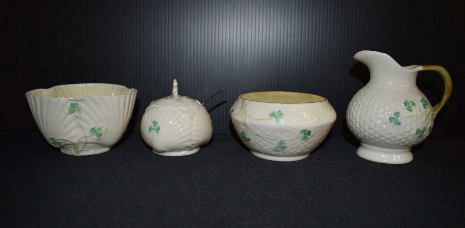 Four Pieces of Mid-Century Belleek: Four Pieces of Mid-Century Belleek. All with with the fifth green mark. Two bowls, 2 1/4"h., a miniature covered sugar with sterling spoon, 2 3/4"h. and a creamer, 3 3/4"h.