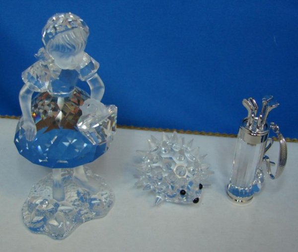 3 Swarovski fig. Little Red Riding Hood, Porcupine: Swarovski crystal Little Red Riding Hood, with a tiny basket on her arm, 3.5" tall, from the Fairy Tales Collection, a little porcupine, and a bag of golf clubs.