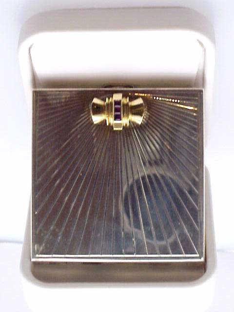 Lady's sterling Tiffany compact/rubies: Lady's sterling silver Tiffany compact with sunburst design on front and Art Deco look of 14kyg and three square rubies. Weighs 4oz and measures 21/2X21/2".