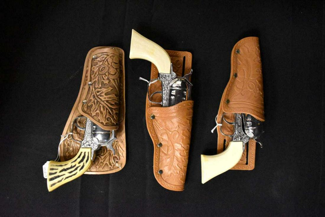 Trio of Vintage Pony Boy Toy Cap Guns w Holsters: Trio of Vintage "Pony Boy" Toy Cap Gun Revolvers with Oak Leaf Vinyl Holsters. Imitation stag grips & imitation nickel finish metal. All appear work correctly. Holsters are LH or RH depending on how t