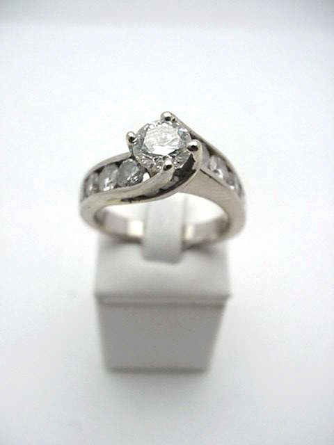 Lady's 14kwg diamond wedding ring 2.00ctw: Lady's 14kwg diamond wedding band 5 grams with one round brilliant cut diamond prong set in the center empire design weighing .70ct with SI2 clarity and I color. On either side of center are 7 channel