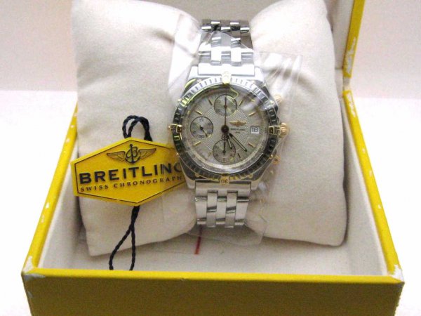 Man's Breitling 18kyg&stain. Chronomat watch: Man's 18kyg and stainless Breitling Chronograph watch with sapphire crystal, white stick dial with three sub dials, water resistant to 100m and never been warn. Comes with original box and manual.