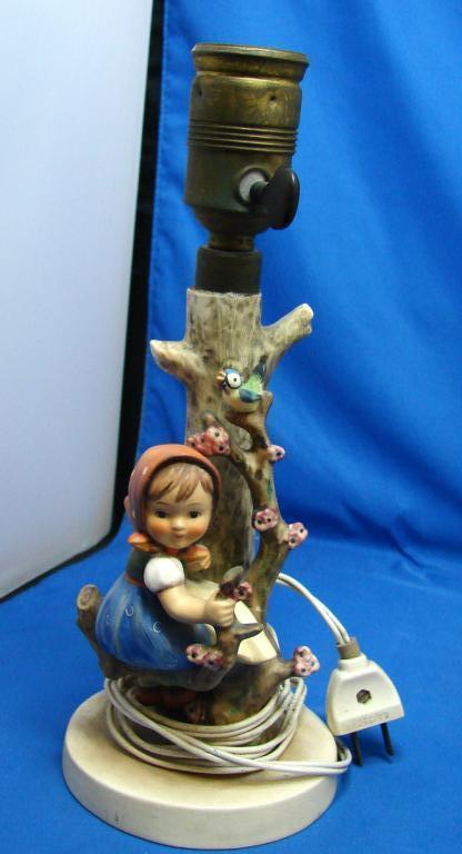 Hummel Apple Tree Girl Lamp, 3 Hummel Plates ++: Hummel Apple Tree Girl Lamp, 10 1/2" tall, small piece broken off branch underneath girl, 3 Hummel Little Plates, a vintage carved wood wine cork, and a Norman Rockwell Football figurine.