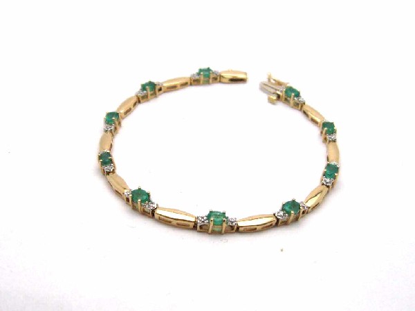 Lady's 14kyg emerald & diamond bracelet: Lady's 14kyg emerald and diamond bracelet 7.8 grams with 10 oval shaped emeralds prong set measuring 4X3mm with diamond on either side. 9mm bar between each emerald and 7" in length.