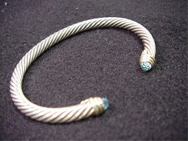 David Yurman bracelet with blue topaz: David Yurman sterling and 14kyg bracelet 5mm width with blue topaz stones mounted in 14kyg bezel.