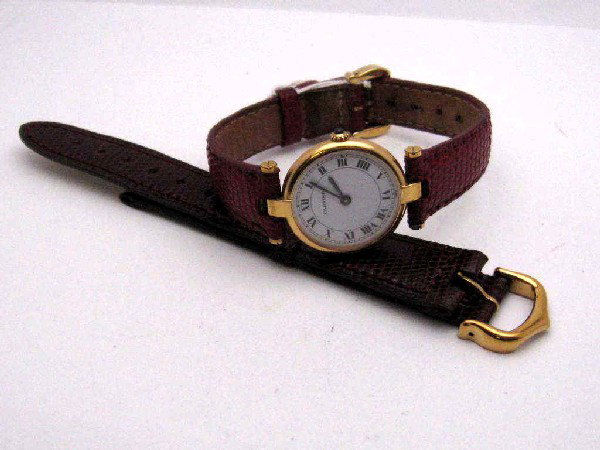Lady's 18kyg Cartier Vendome dress watch: Lady's 18kyg Cartier Vendome dress watch with quartz movement, sapphire crown, white roman dial, red leather band and 2 extras. Comes with box.