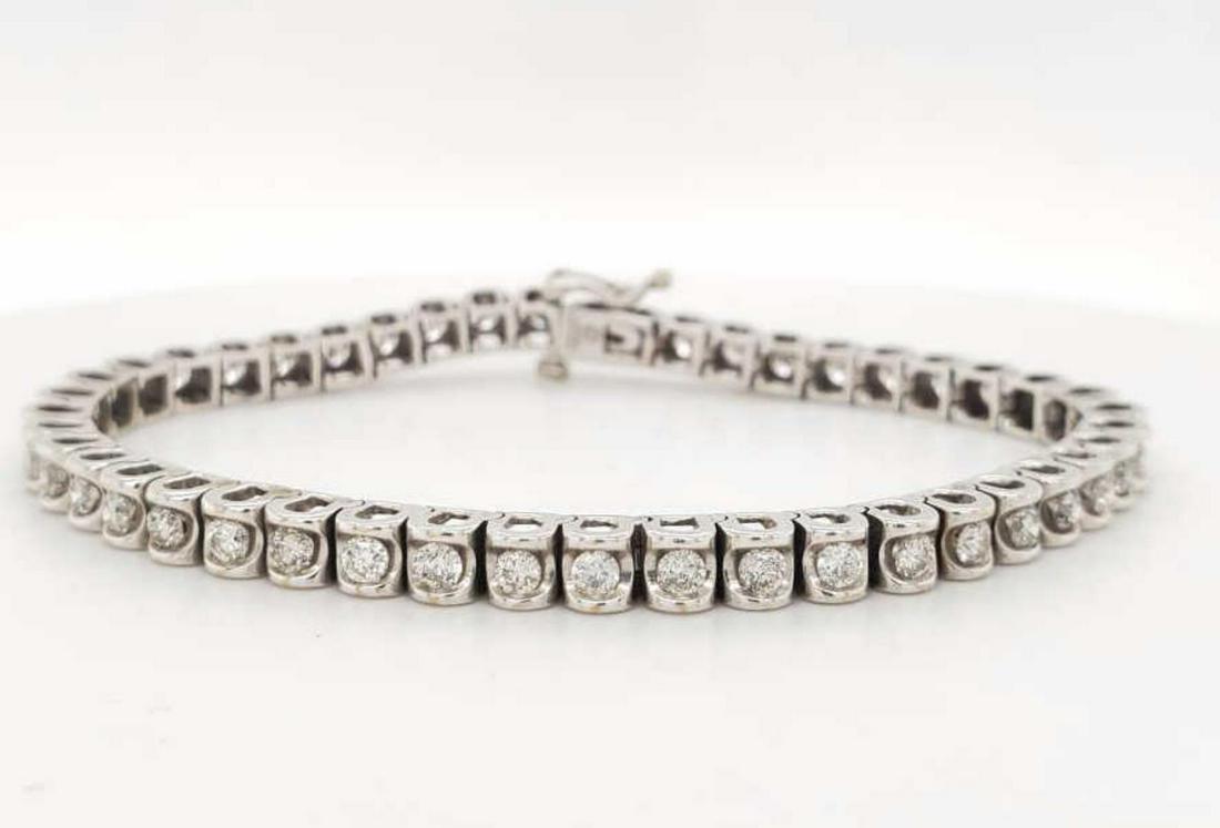 14kt white gold diamond tennis bracelet: Ladies 14kt white gold diamond tennis bracelet featuring channel set round brilliant cut diamonds weighing approx. 2.70ct. Length7". Weight 17.6 grams