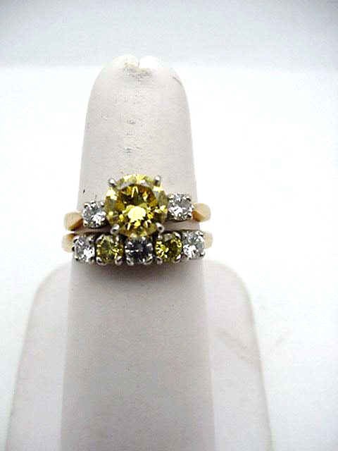 14kyg fancy yellow diamond bridal set: Lady's 14kyg diamond bridal set 5.8 grams with one round fancy yellow diamond weighing 1.11ct yellow intense color and VS1 clarity with 2 round diamonds one on either side .20ctw clarity VS1 and H col