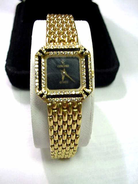 Lady's 18kyg Concord diamond onyx watch: Lady's 18kyg Concord diamond watch 46 grams with black onyx dial, diamond and onyx bezel, case measuring 18X18mm with adjustable panther link bracelet. Comes with original box and manual.