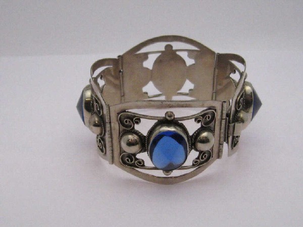 Sterling silver bracelet with blue stone: Lady's sterling silver bracelet 7 inches in length 4 hinged sections in filigree with oval shaped blue stone bezel set in the center measuring 17X12mm with bracelet 35mm in width.