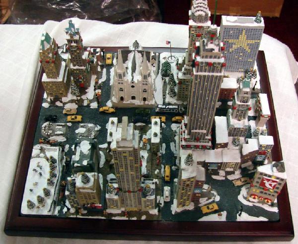 Danbury Mint Christmas in New York Retired: Danbury Mint Christmas in New York, 11" x 12.5"; featuring all the famous NY buildings including Empire State Bldg., retired figurine; we see no chips or cracks or missing pieces.