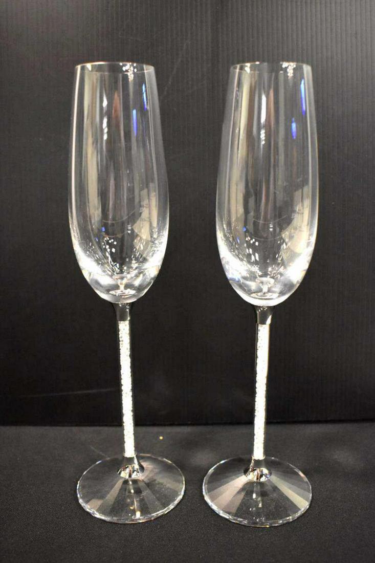 Pair Of Swarovski Toasting Flutes: Pair Of Swarovski Toasting Flutes. Comes with original box. Measures 11" tall. Designer Steven Weinberg. Comes with Swarovski Crystal Certificate booklet. Flutes have crystal stones in the stem.