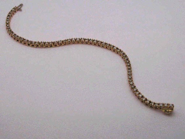 14kyg prong set diamond bracelet 2.50ctw: Lady's 14kyg diamond bracelet 10 grams with round full cut diamonds prong set in a straight line design weighing approx. 2.50ctw. 7 inches in length with under clasp safety.