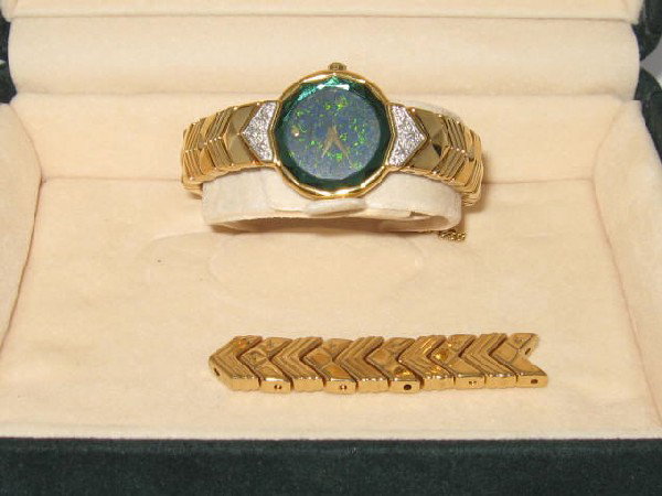 Seiko Lassalle bracelet watch: Lady's Seiko Lassalle gold tone bracelet watch with quartz movement, opal dial, green faceted crystal, diamond lugs and safety clasp. Comes with original box.