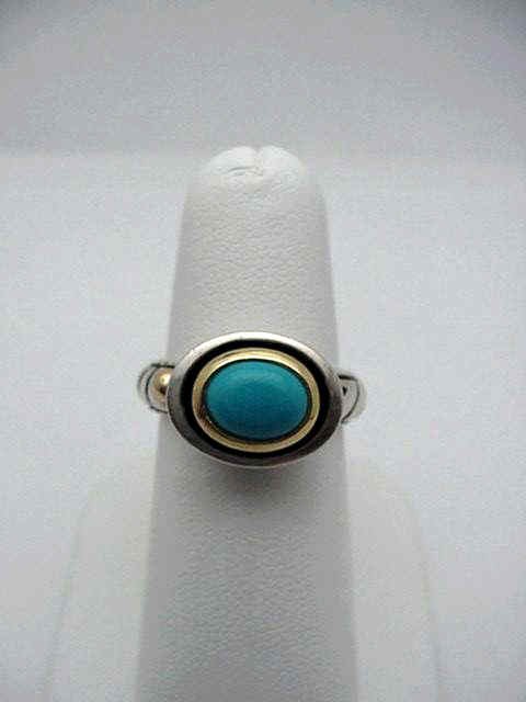 Sterling 18kyg ring by John Atencio: Sterling silver and 18kyg designer ring by John Atencio 7.8 grams with oval shaped turquoise measuring 7x5mm bezel set in 18kyg with enameling in the shank. Finger size 6 1/4.