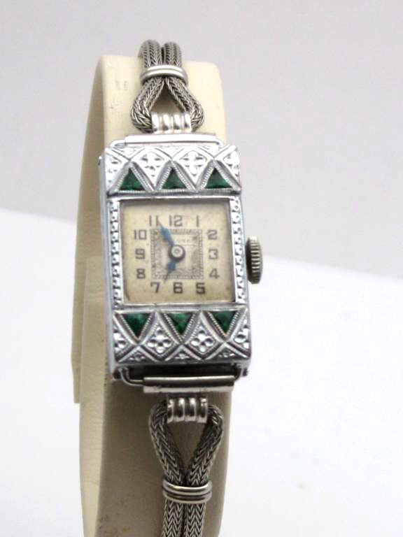 Vintage 14kwg Bulova emerald watch: Lady's vintage Bulova watch 12 grams 24X14mm case with square dial and black hands, 6 triangle shaped natural emeralds three on top and bottom with silver nylon band. Good working condition.