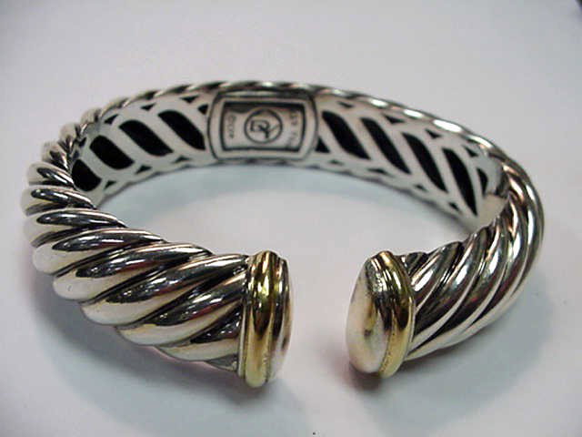 Sterling & 18kyg David Yurman bracelet: Sterling and 18kyg bracelet by designer David Yurman antique barber pole design with 18k yellow bars denoting end. Approx. 5/8" in width with hinged opening.