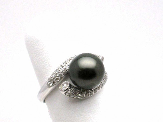 18kwg Tahitian pearl & diamond ring: Lady's 18kwg pearl and diamond ring 5.7 grams with one Black Tahitian pearl measuring 10mm surrounded by pave diamonds in a bypass design. Finger size 6 1/2.
