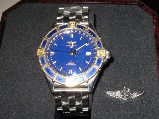 Stainless Breitling J class watch: Man's stainless and gold Breitling J class automatic, Swiss movement #7560, water resistant, blue dial box and papers. Sold AS IS!