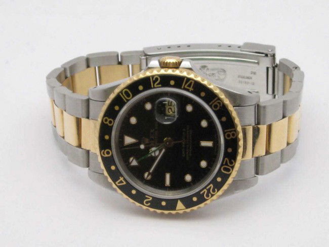 Man's Rolex GMT Master II watch: Man's Rolex GMT Master II Date watch 18kyg and stainless with black dial, automatic movement, sapphire crystal and oyster band.