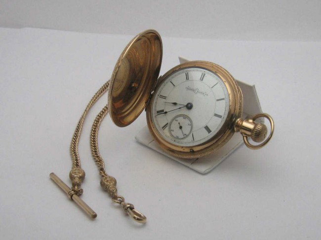 Illinois Pocket watch with fob: Gold filled Illinois pocket watch white roman dial,second hand inset, sculpted filigree case with fob. Not in working condition.