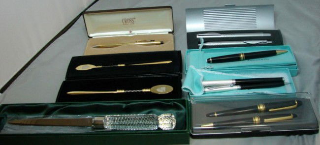Lot of Pens: Tiffany, Cross, Nino Cerruti ++: Box lot of pens: Tiffany black ball point pen, Nino Cerruti Pen & Pencil set in Tiffany box, Cross Pen, 2 unmarked sets, 2 gold letter openers and a crystal letter opener, all in original boxes.