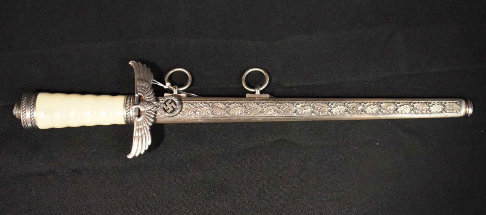 Replica German Dagger With Oak Leaf Scabbard: Replica German Dagger With Oak Leaf Scabbard. Paul Weyersberg & Co. Berlin, marked on bolster. Hanging rings, resin white handle, spread eagle with swastika, knot thread pommel, oak leaf guard, leathe