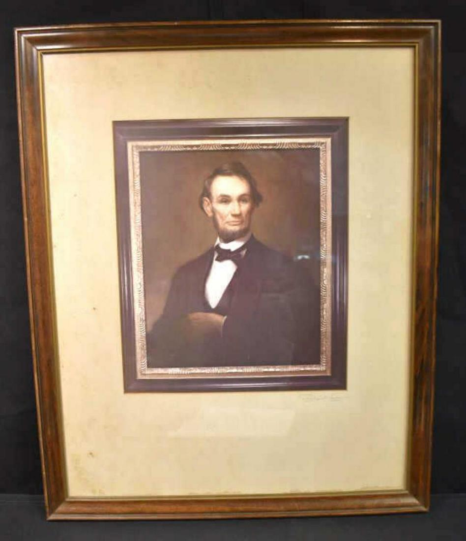 Framed photo of a portrait of Abraham Lincoln: Framed photo of a portrait of Abraham Lincoln. Measures 17 1/2"x 21 1/2". Wood frame. Artist signature located lower right hand corner. Depict Abraham Lincoln posing with his arms folded. Print has a 