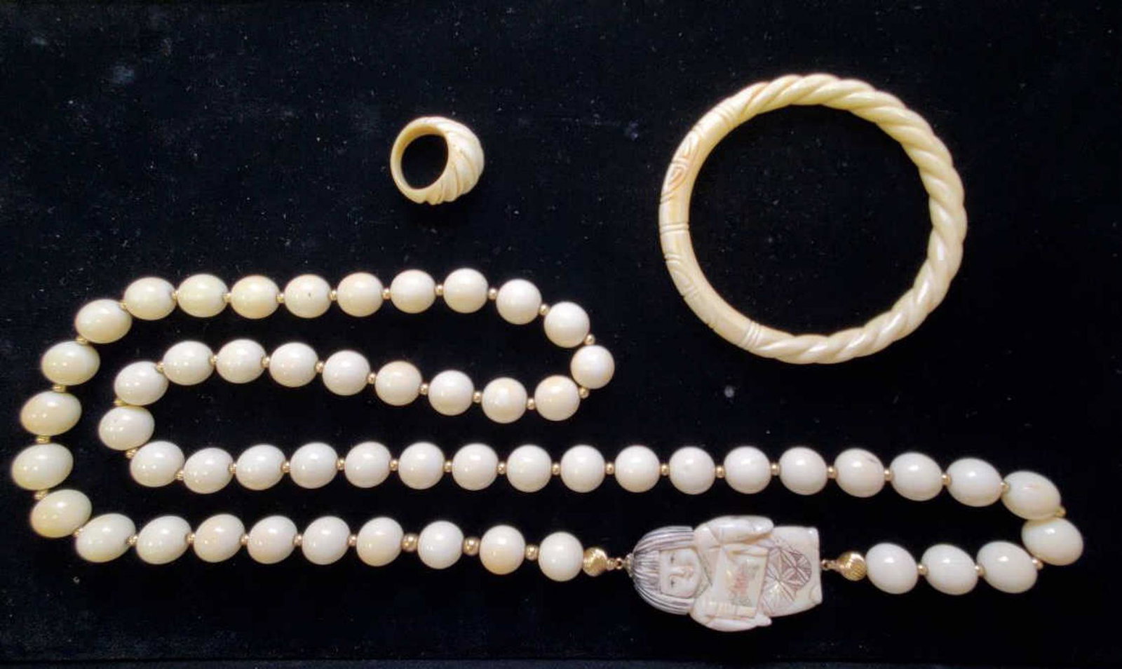 Lot of carved ivory/ bone jewelry: Lot of carved ivory bone jewelry including an 11mm bead necklace with geisha carving, 8mm wide bangle bracelet and carved dome ring. Bangle inner diameter 2.5". Ring size 7 1/4.
