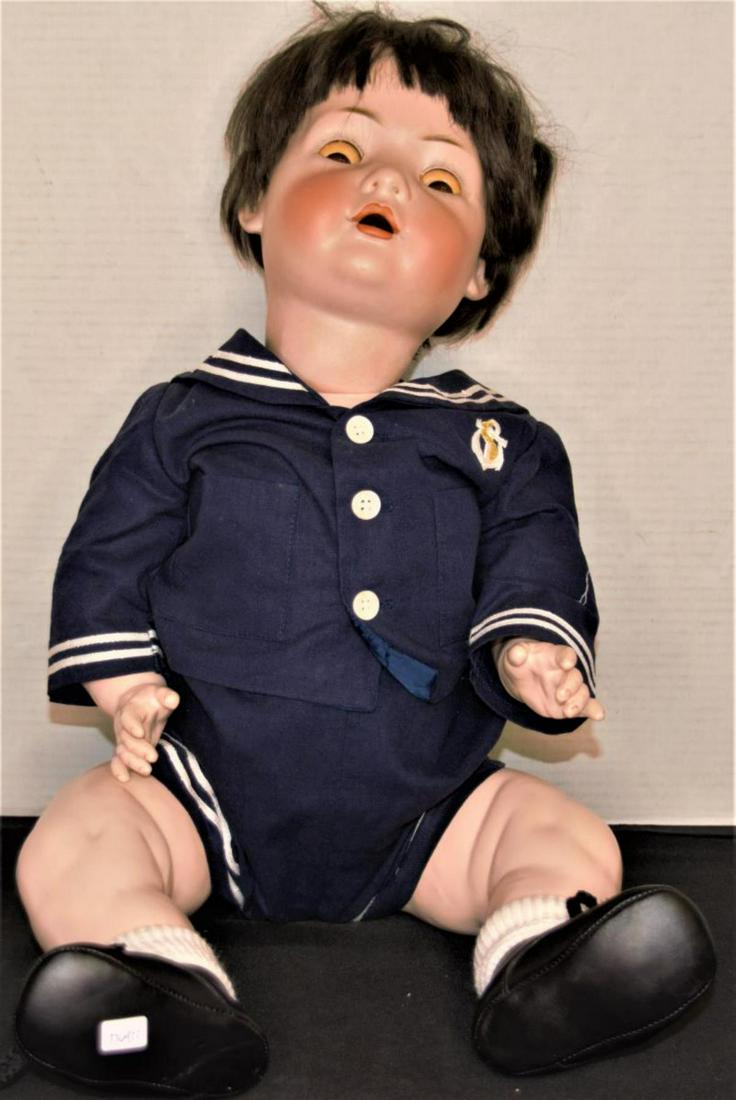 Bruno Schmidt Bisque Doll: Bruno Schmidt Bisque Doll. Brown wig. Composition ball jointed body. Glass sleep eyes. Naval outfit. Measures 27" in height. Some wear on hands. White painted spot on right shoe.