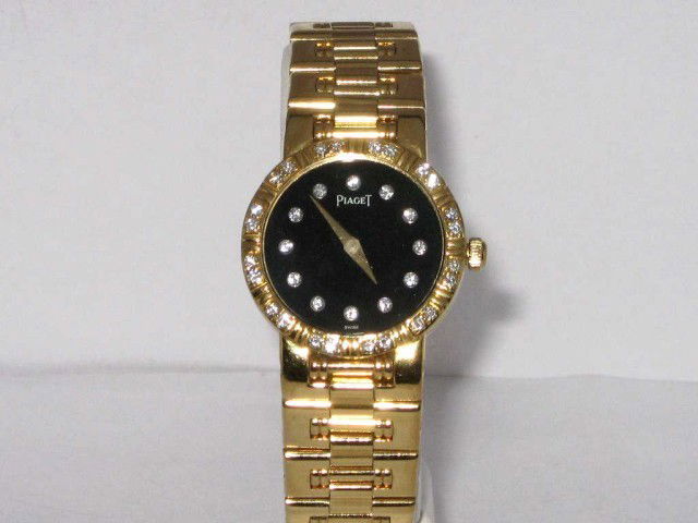 Lady's 18kyg Piaget Dancer watch: Lady's 18kyg Piaget Dancer diamond watch 58gr with black diamond dial,diamond bezel and tapered link band. Needs new movement. Comes with original box and operating manual.