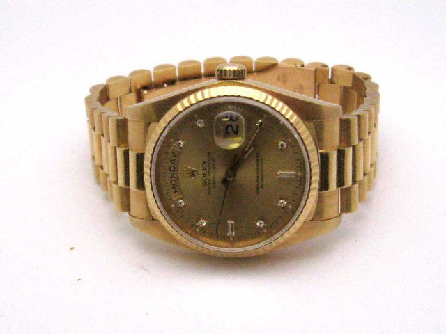 Man's 18kyg Rolex President watch: Man's 18kyg Rolex President gold dial with round and baguette diamonds,single quickset calendar, automatic mechanical movement and in good running condition.