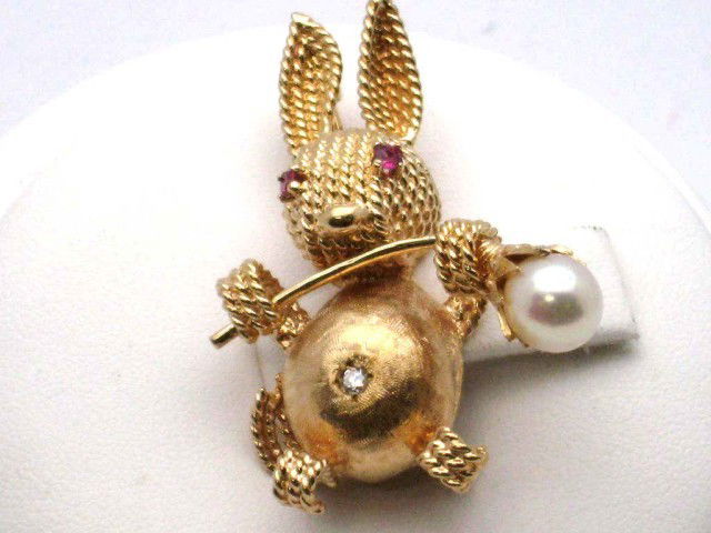 14kyg rabbit brooch with diamond: 14kyg rabbit brooch 13.2gr with diamond in the belly,rubies in the eyes and holding a pearl flower.