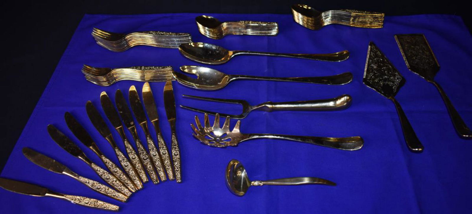 Gold Plated Flatware: Gold Plated Flatware. Consists of ladle measuring 6 1/2" in diameter. Caving fork measuring 11 1/4" in diameter. Pair of cake knives measuring 11 1/2" in diameter. 3 serving utensils measuring from 10