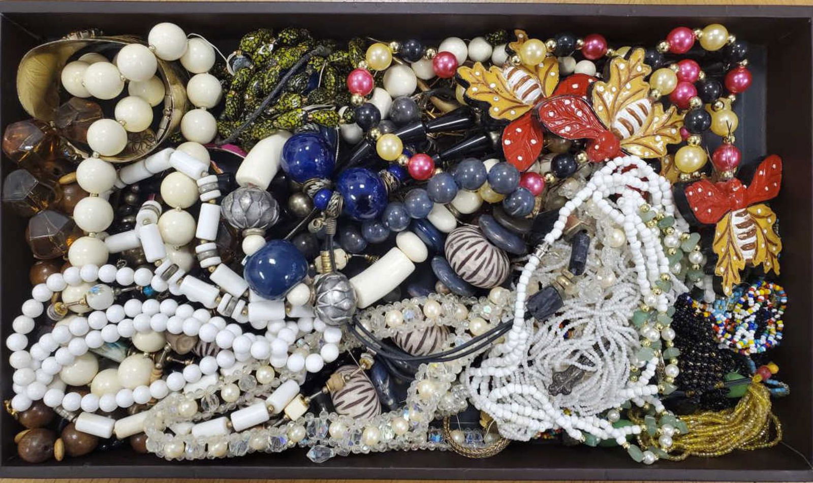 Large lot of costume jewelry: Large lot of costume jewelry featuring beaded necklace, bangle bracelets, wide cuff bracelet, fancy wide link bracelets, fancy link chains, and much more.