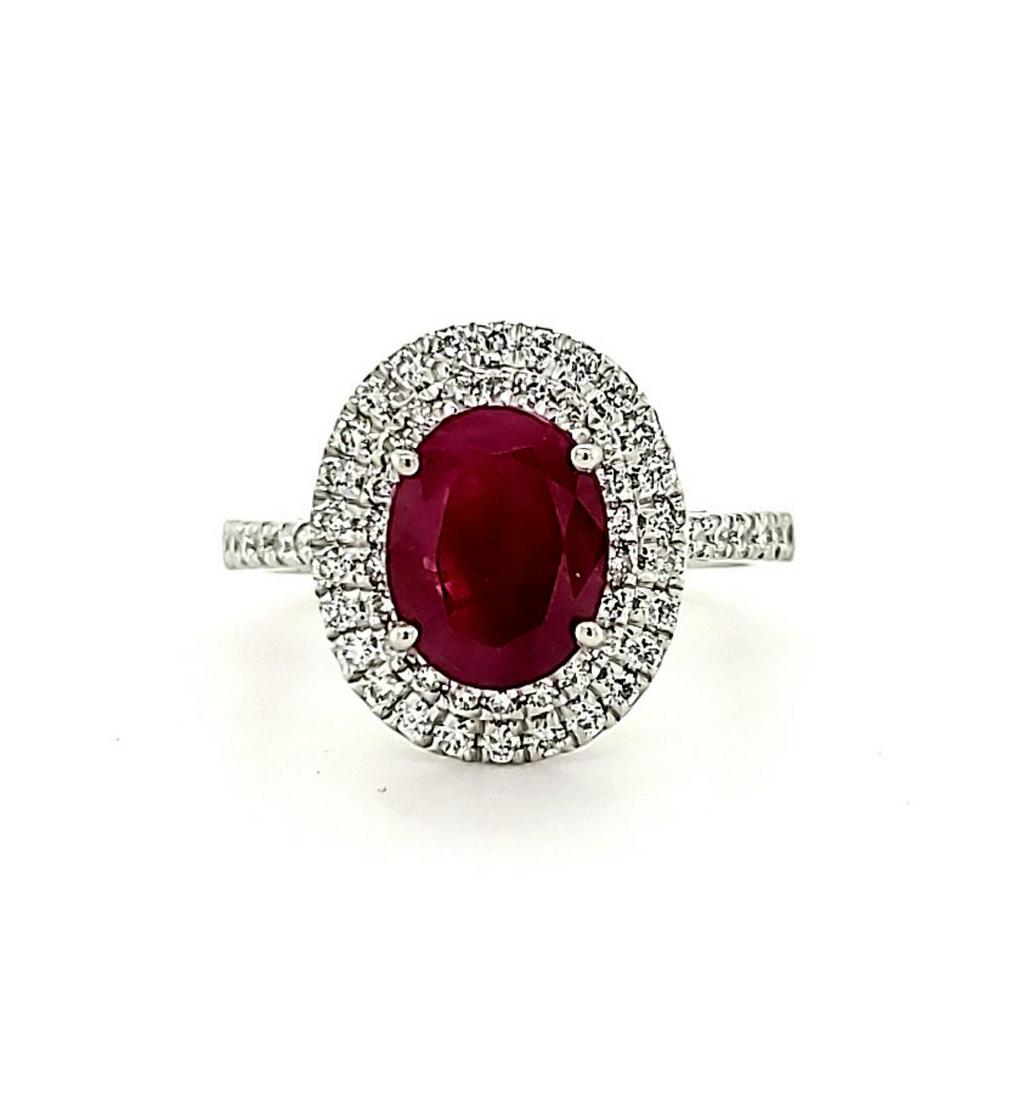Platinum Burmese ruby and diamond ring: Ladies platinum ruby and diamond ring featuring a prong set oval cut ruby weighing 2.39ct, Geographic Origin Burma. Surrounded by a halo of prong set round brilliant cut diamonds weighing approx. 0.45
