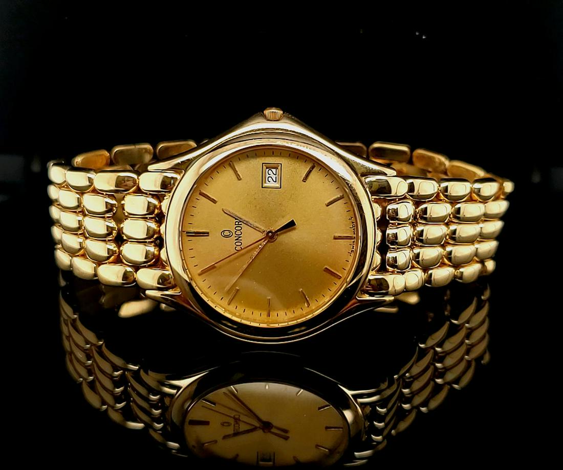 Man's 14kt yellow gold Concord Quartz Watch: Man's 14kt yellow gold Concord watch featuring panther style bracelet, quartz movement, champagne crystal with stick markers, and date window. Length 8". Gross weight 66.5 grams.