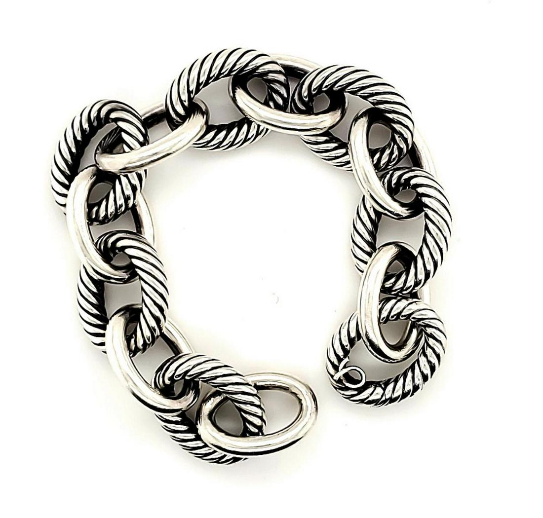 Sterling silver David Yurman Cable link bracelet: Ladies sterling silver David Yurman cable link bracelet featuring large oval shaped links accented with a signature twisted cable design alternating with high polish links. Finished with a hidden clas
