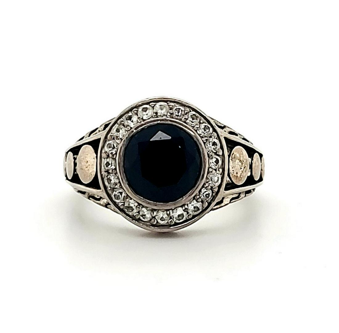 Sterling Silver John Hardy Black Onyx Dot ring: Ladies sterling silver John Hardy Black Onyx Dot ring featuring a bezel set round black onyx measuring 8mm. Surrounded by a halo of white sapphires and accented with a signature dot pattern. Finger si